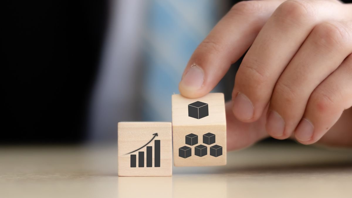 Eine Hand platziert Holzblöcke mit Symbolen für Wachstum und Struktur.