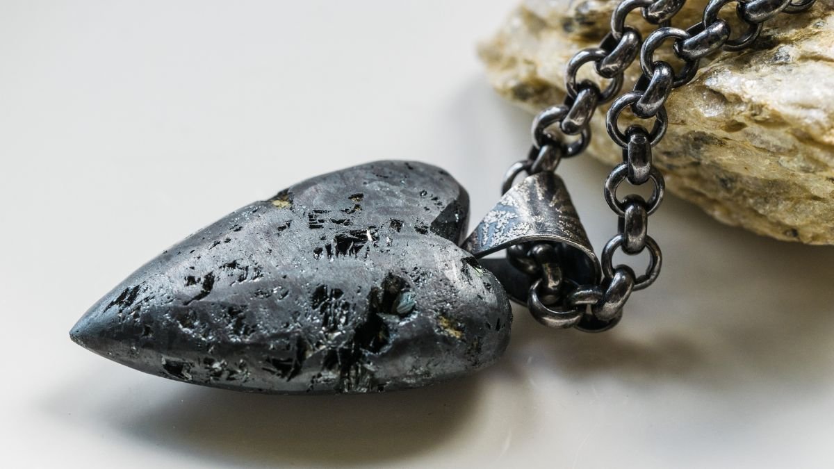 Ein herzförmiger Hämatit-Anhänger an einer Kette, der Stabilität symbolisiert.