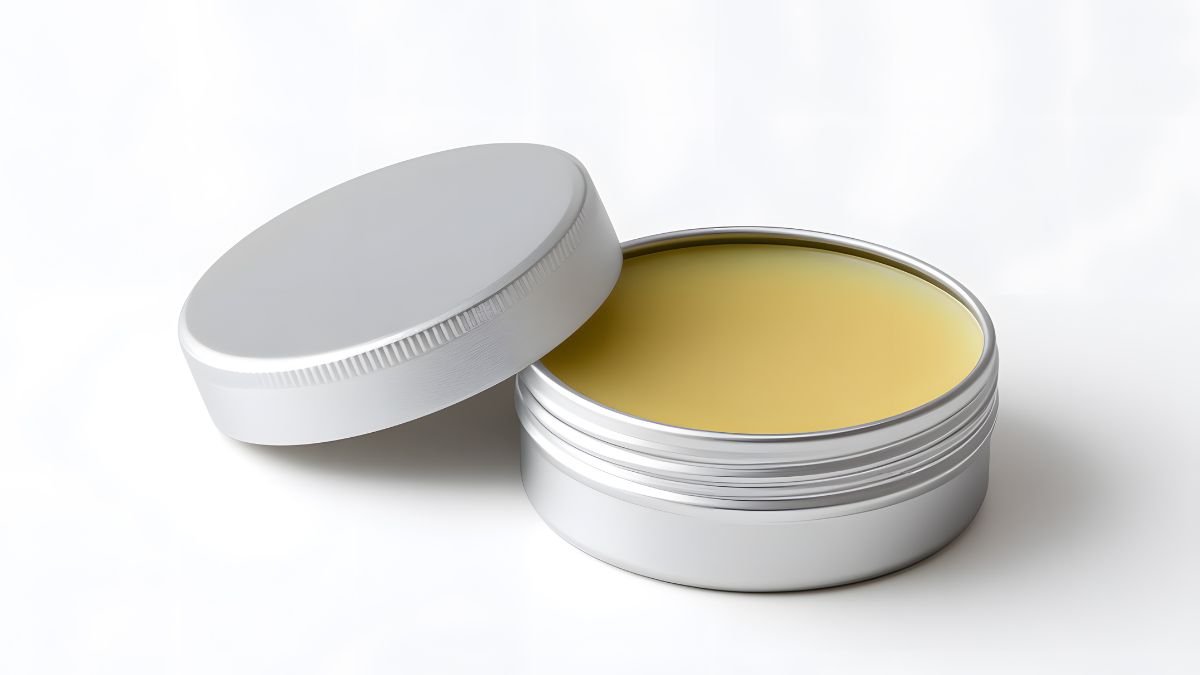 Eine geöffnete Dose mit grüner Pferdesalbe, die eine gelbliche Farbe hat.