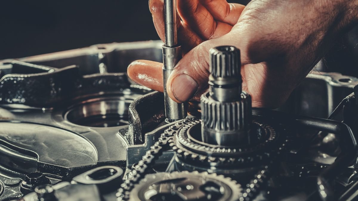 Eine Hand arbeitet an einem Motor, um die Ventilsteuerung zu justieren.