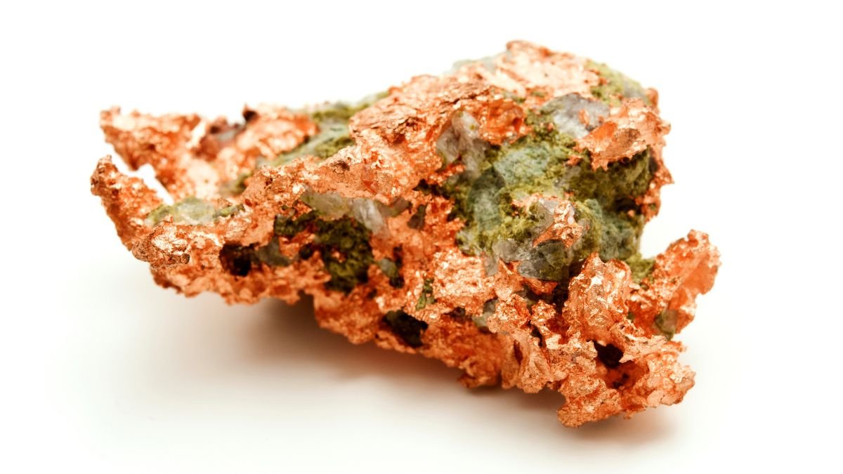 Ein Stück Kupfererz mit grünlichen Mineralien und metallischer Oberfläche.