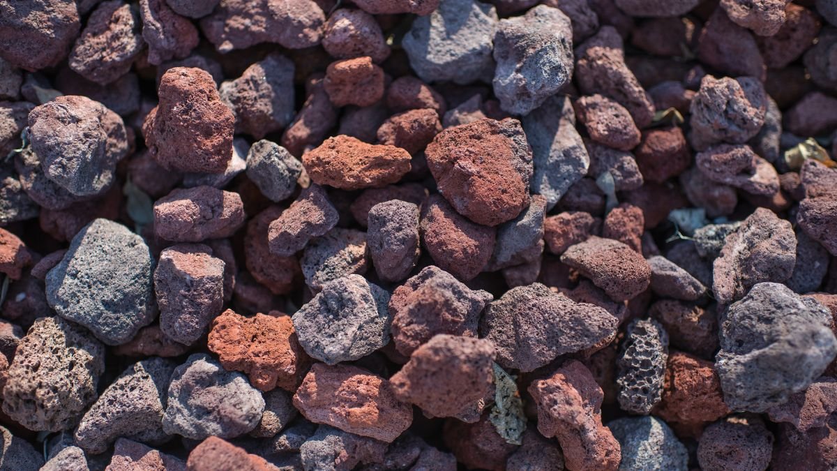 Eine Nahaufnahme von Lavasteinen in verschiedenen Rottönen und Texturen.