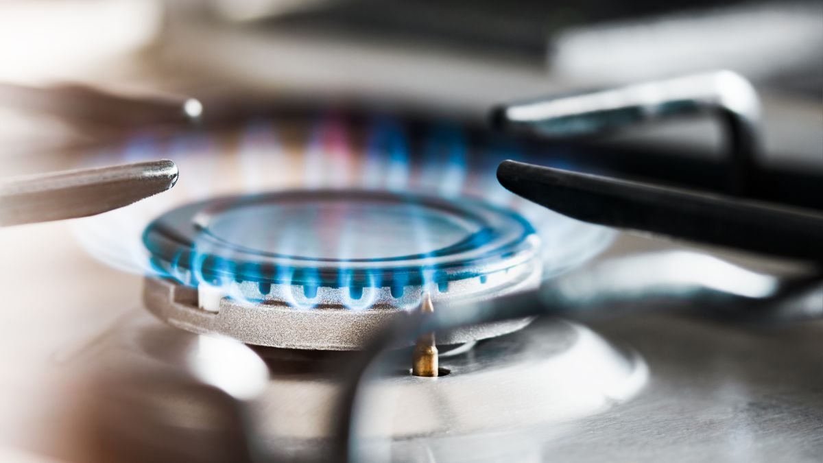 Nahaufnahme einer Gasflamme auf einem Herd, die für das Kochen verwendet wird.