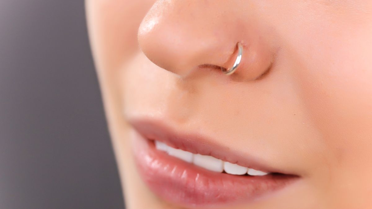 Nahaufnahme einer Person mit einem Nasenpiercing aus Silber.