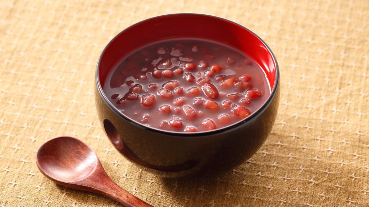 Eine Schüssel mit roten Bohnen in einer süßen Brühe auf einem Tisch.