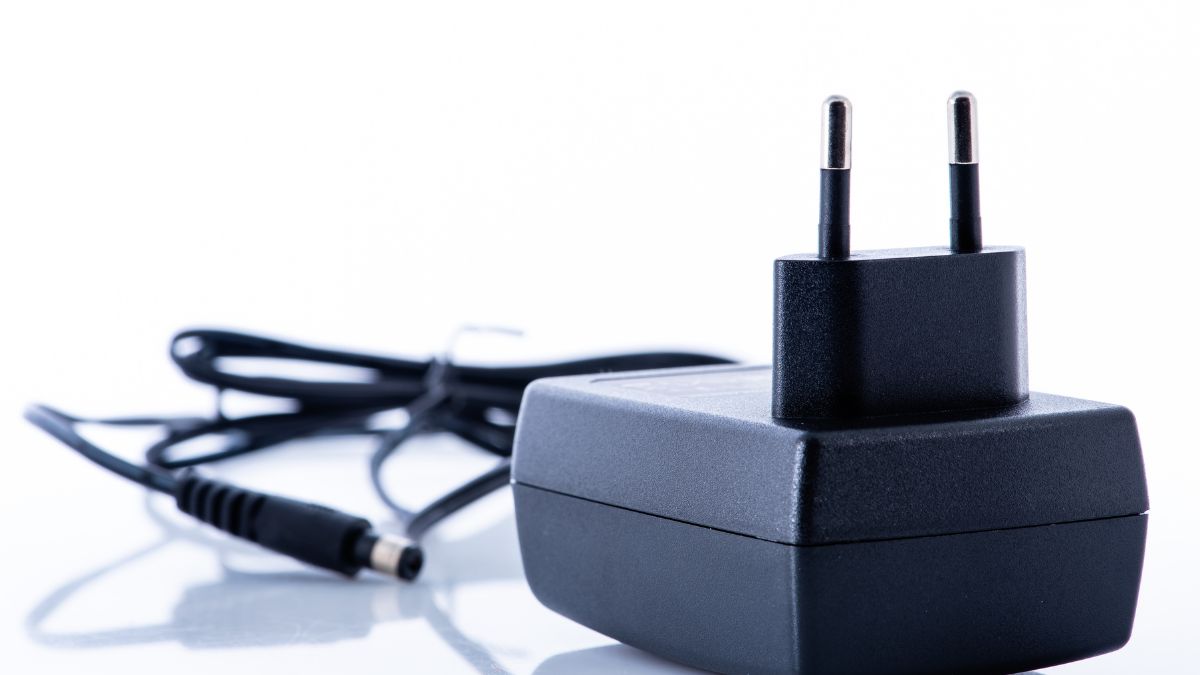 Ein schwarzes Netzteil mit zwei Stiften und einem Kabel.