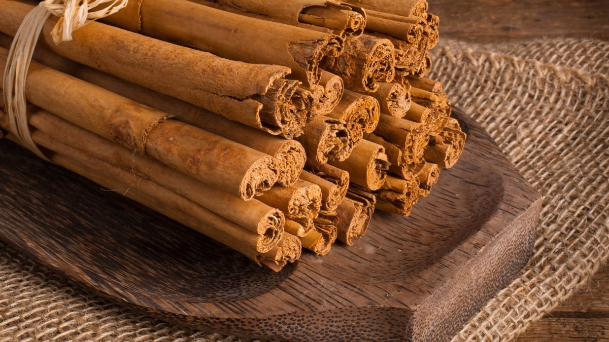 Ein Haufen Zimtstangen auf einem Holzbrett, bereit für die Verwendung in der Küche.