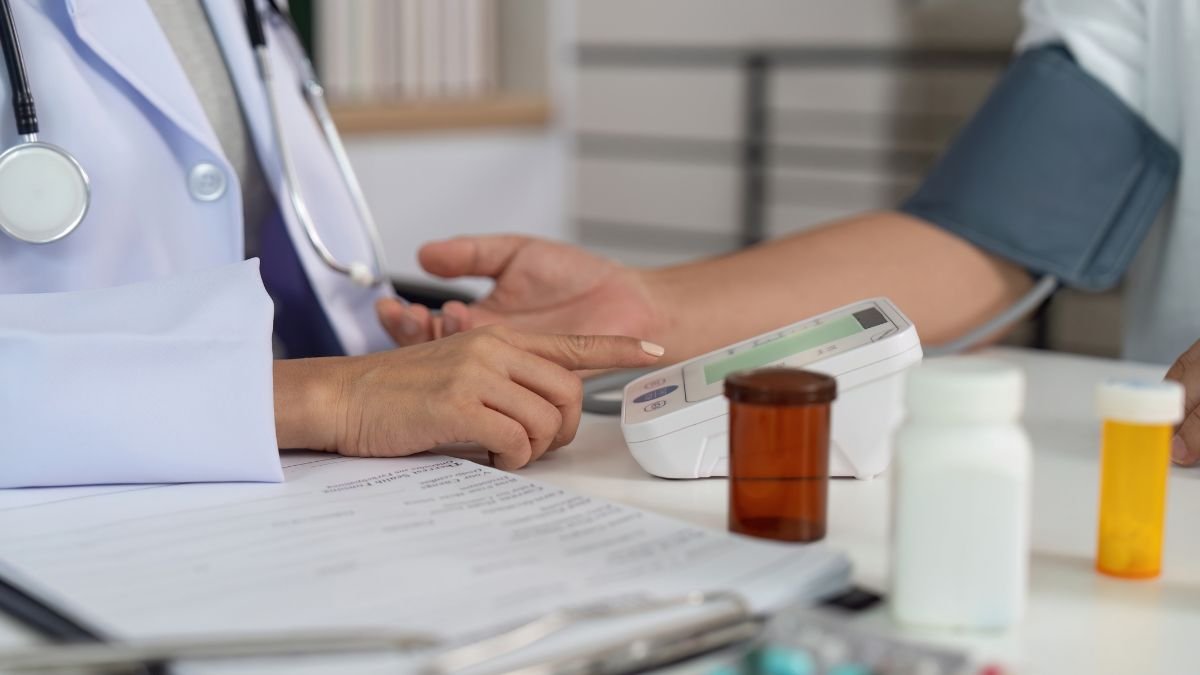 Ein Arzt misst den Blutdruck eines Patienten mit einem digitalen Gerät.