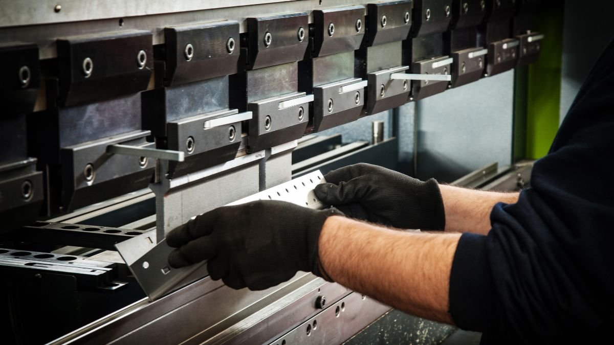 Ein Arbeiter bedient eine CNC-Abkantpresse zur Blechbearbeitung.