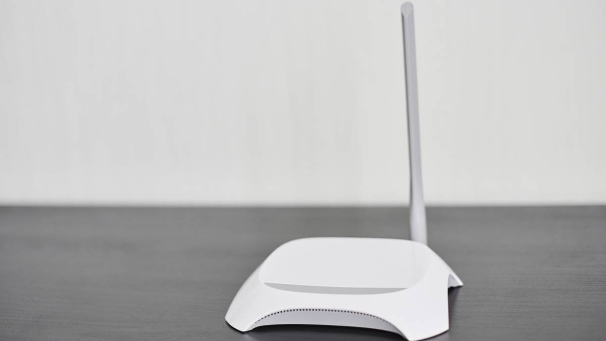 Ein moderner WLAN-Router mit einer Antenne auf einem Tisch.