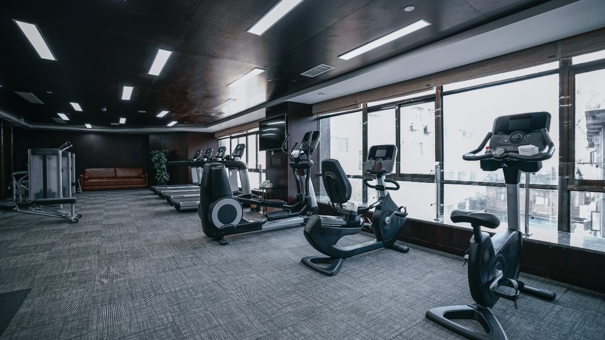 Ein modernes Fitnessstudio mit verschiedenen Trainingsgeräten und viel Tageslicht.