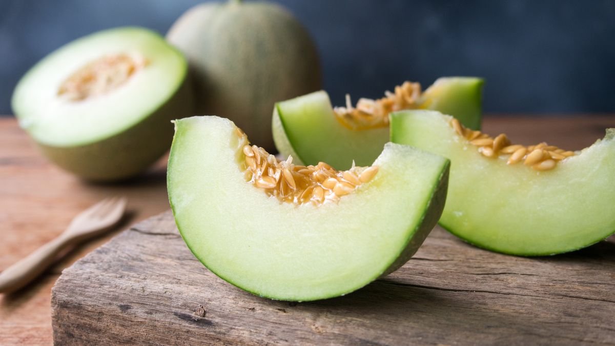 Frische Honigmelonenstücke auf einem Holzbrett, saftig und süß.