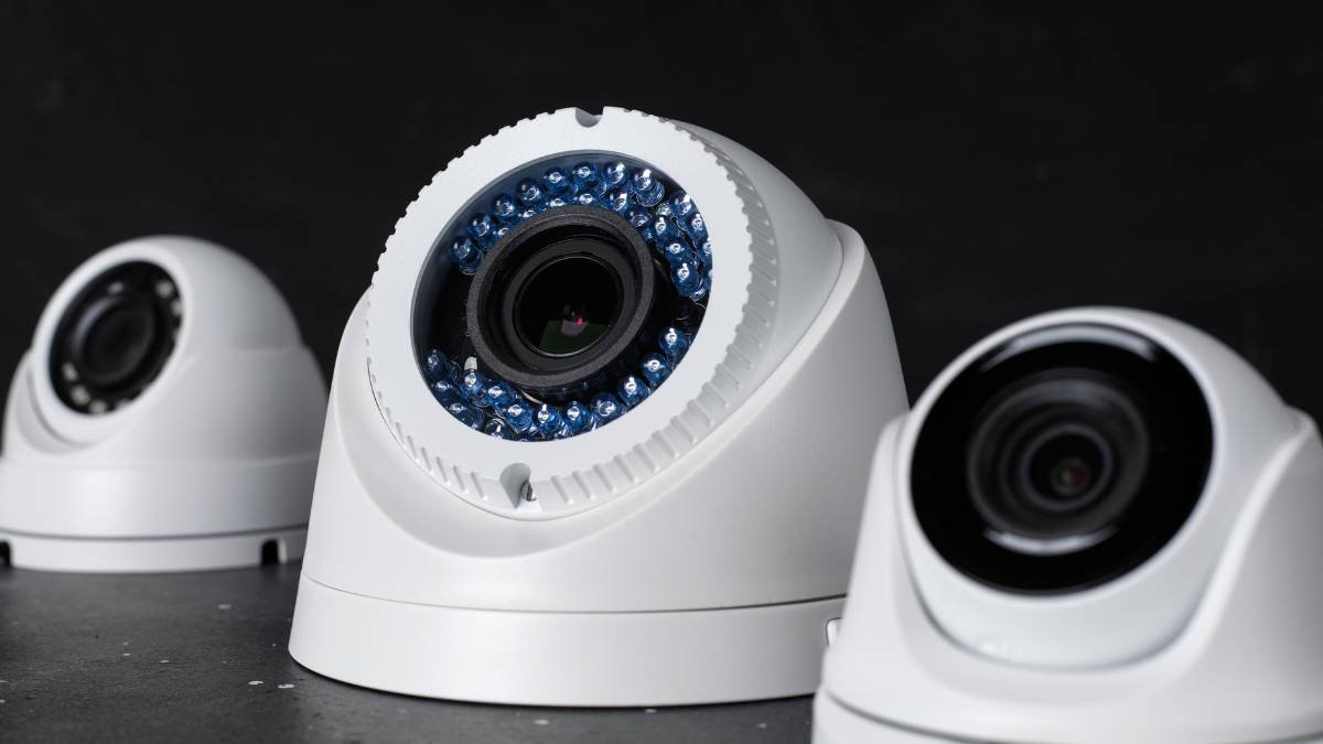 Drei moderne IP-Kameras mit unterschiedlichen Objektiven auf einem Tisch.