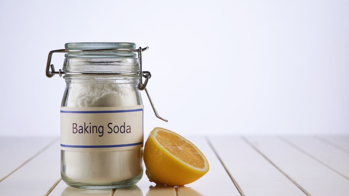 Ein Glas mit Natron und einer halben Zitrone auf einem Tisch.