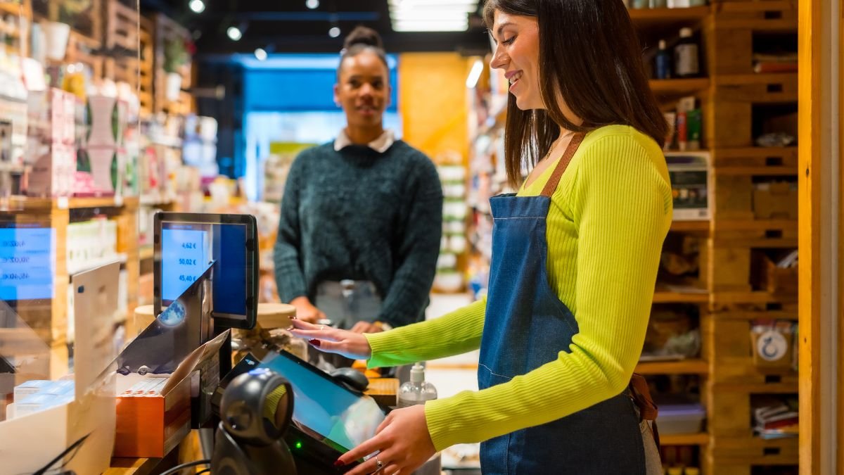 Eine Kassiererin bedient eine moderne Online-Kasse in einem Geschäft.