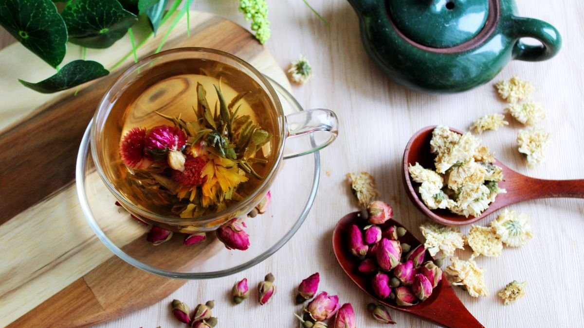Eine Tasse Pai Mu Tan Weißtee mit getrockneten Blüten und Kräutern.
