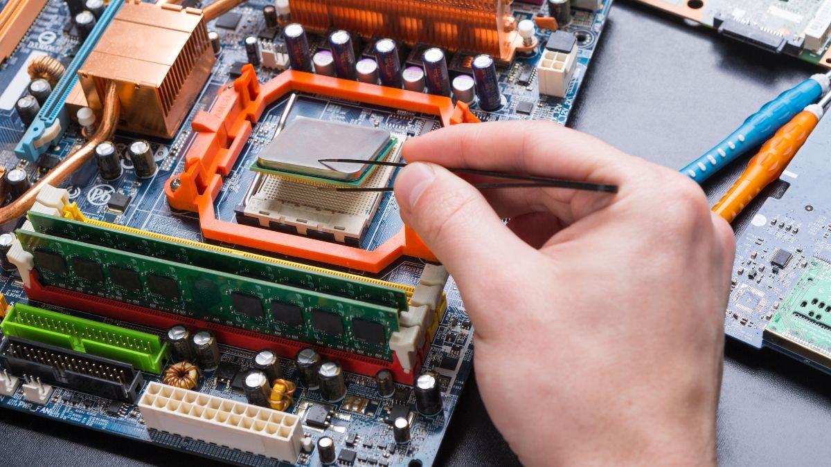 Eine Hand platziert vorsichtig einen Prozessor auf einem Motherboard.