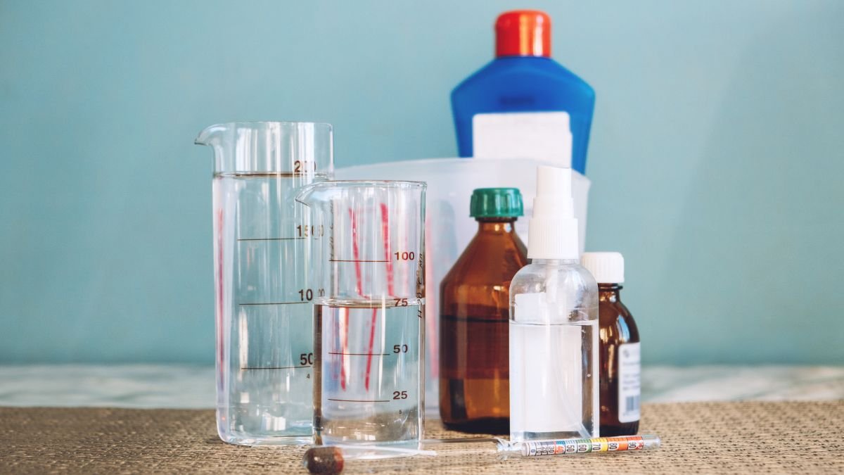 Verschiedene Flaschen und Messbecher mit Wasserstoffperoxid im Haushalt.