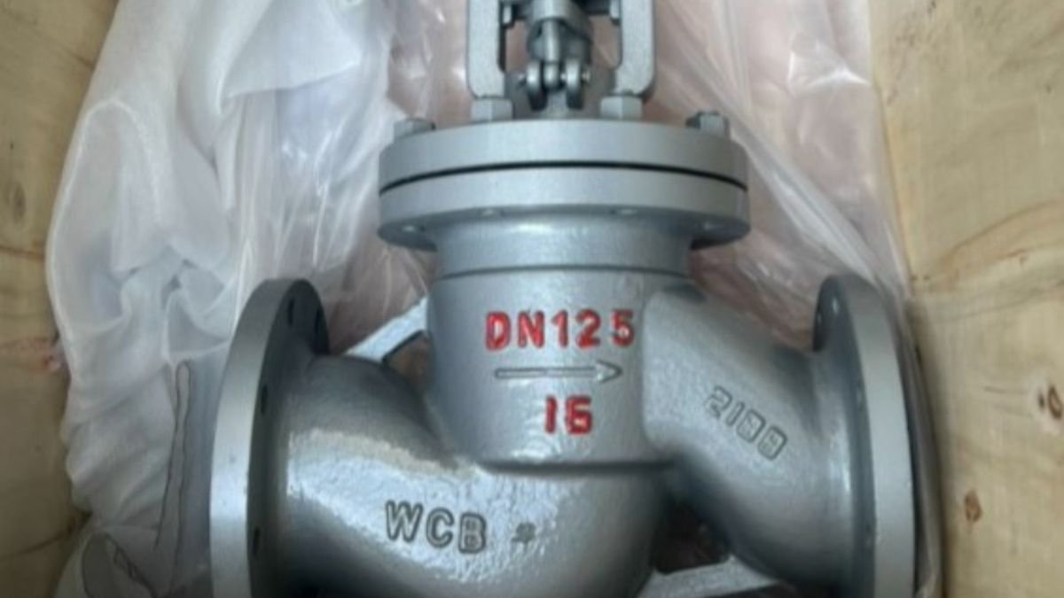 Ein 3-Wege-Umschaltventil aus grauem Metall, das in einer Holzkiste verpackt ist.