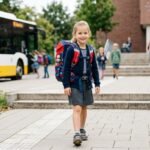 Kind trägt eine falsch gepackte Schultasche und belastet dabei den Rücken unnötig